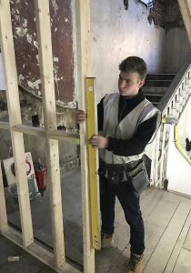 Construction apprentice checking his work